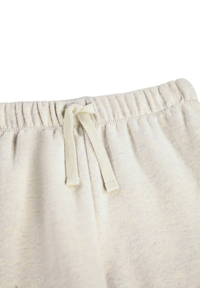 Close-up of beige pants with drawstring on a white background