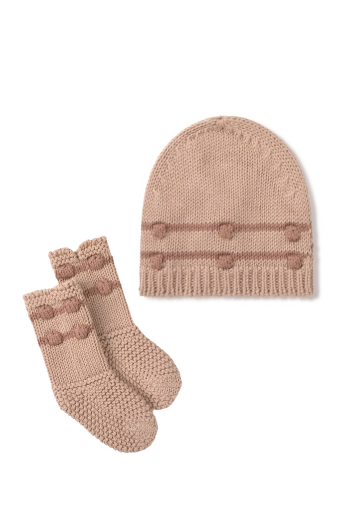 Knitted baby hat and booties set in beige on a white background