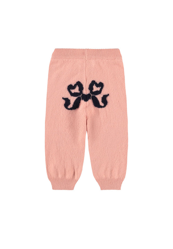 Pink knitted pants with black bow design on a white background